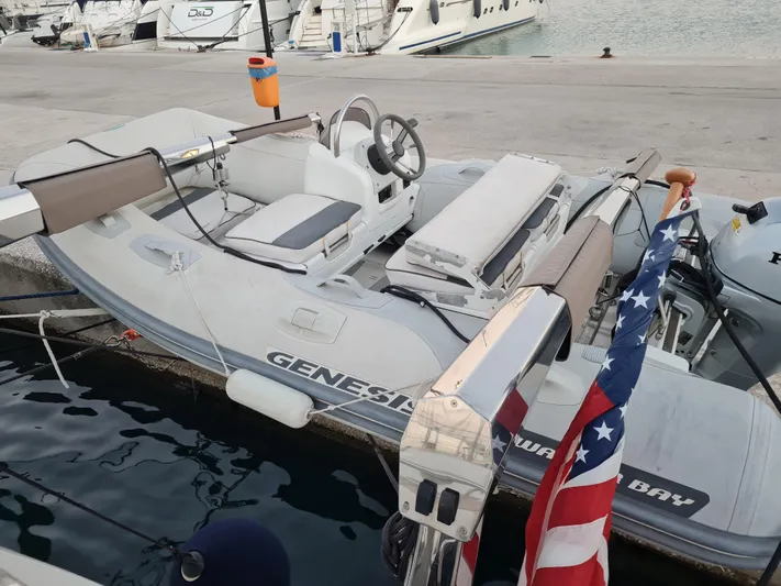  Yacht Photos Pics Inflatable boat docked, Jeanneau 57, 2015 model, with American flag, marina background.