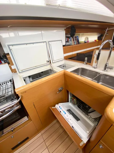 Yacht Photos Pics Modern kitchen in a 2015 Jeanneau 57 yacht with wood cabinetry and stainless steel sink.