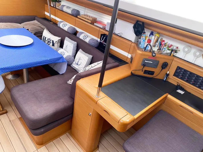  Yacht Photos Pics Interior of 2015 Jeanneau 57 yacht with cozy seating, table, and navigation station.