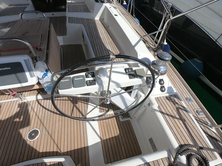  Yacht Photos Pics Steering wheel of a 2015 Jeanneau 57 yacht with teak deck and navigation controls.