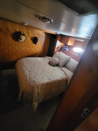 Dunn It Again Yacht Photos Pics Cozy bedroom in 1997 McKinna 48' Pilot House with wood paneling and decorative bedding.