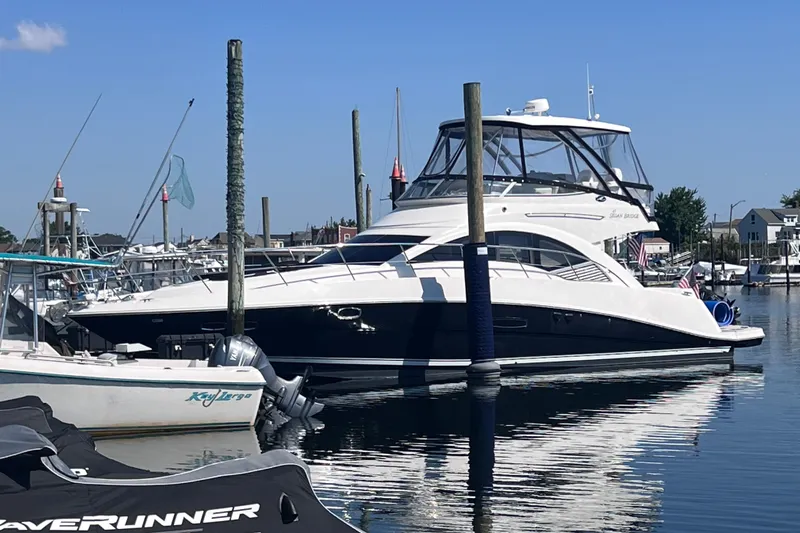  Yacht Photos Pics 2008 Sea Ray 47 Sedan Bridge yacht docked in a marina on a sunny day.