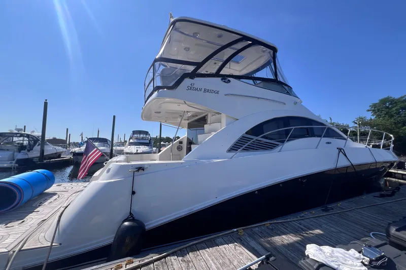  Yacht Photos Pics 2008 Sea Ray 47 Sedan Bridge yacht docked at marina under clear blue sky.