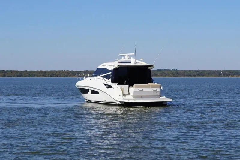  Yacht Photos Pics 2015 Sea Ray 470 Sundancer yacht cruising on a calm lake under clear blue skies.