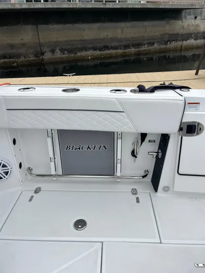  Yacht Photos Pics 2023 Blackfin 272 DC boat interior with sleek white seating and storage compartment.
