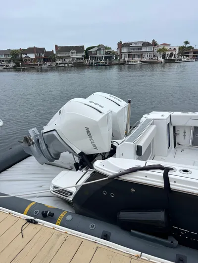  Yacht Photos Pics 2023 Blackfin 272 DC boat with twin Mercury engines docked by waterfront homes.