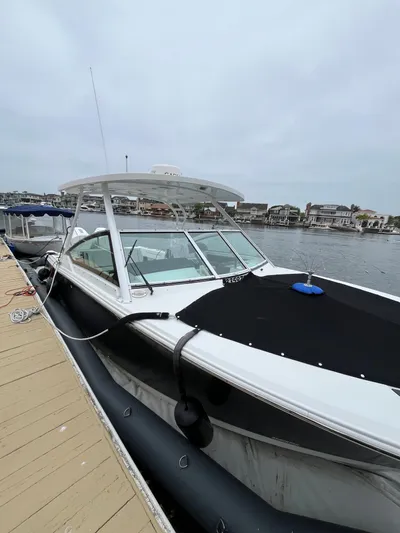  Yacht Photos Pics 2023 Blackfin 272 DC boat docked at marina, overcast sky, waterfront homes in background.