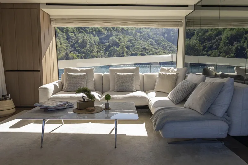  Yacht Photos Pics Luxurious Sanlorenzo SX76 2023 yacht interior with elegant sofa and scenic window view.