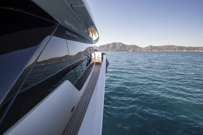  Yacht Photos Pics 2023 Sanlorenzo SX76 yacht cruising on serene blue waters with scenic mountain backdrop.