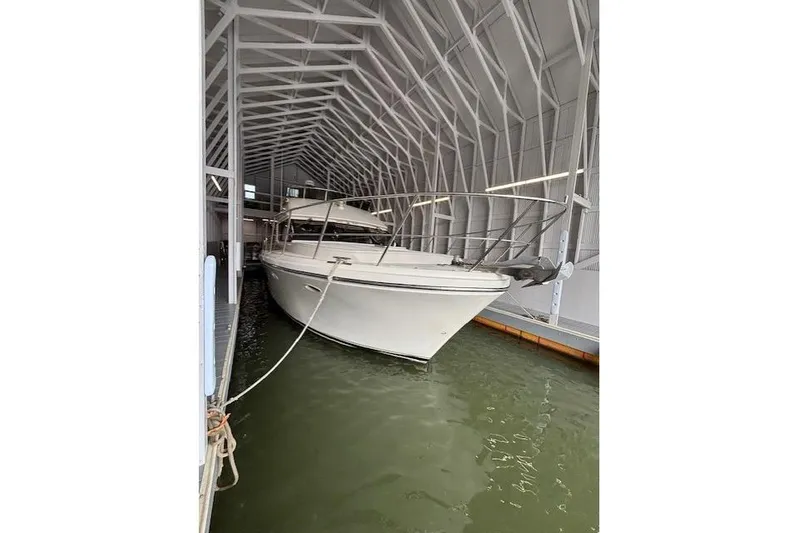 Aqua Billy Yacht Photos Pics Large white boat docked in a covered marina, surrounded by calm water.