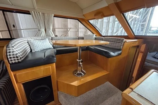 Aqua Billy Yacht Photos Pics Luxurious yacht interior with cushioned seating and wooden table, featuring elegant design elements.