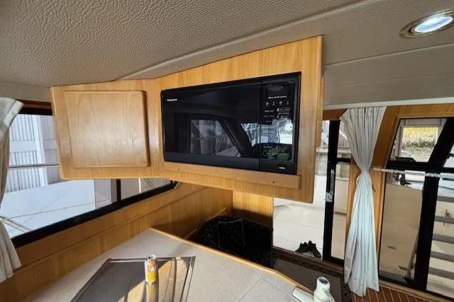 Aqua Billy Yacht Photos Pics Interior of a 1995 Symbol Super Sedan with a built-in microwave and wooden cabinetry.
