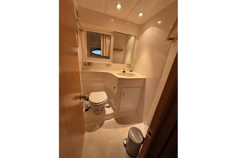 Aqua Billy Yacht Photos Pics Compact bathroom with toilet, sink, mirror, and warm lighting in a 1995 Symbol Super Sedan.