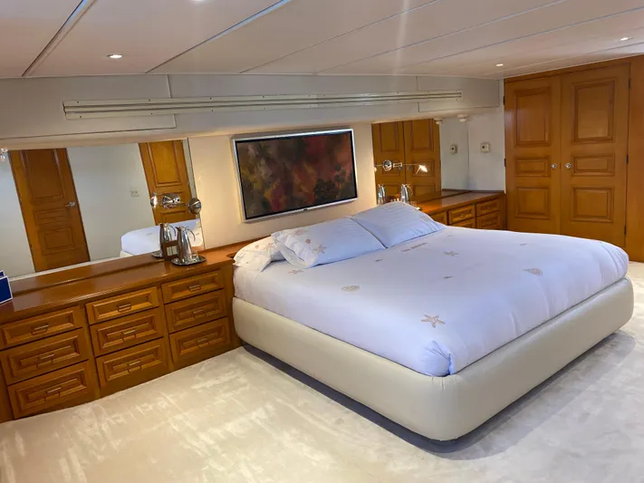 Mi Amor Yacht Photos Pics Luxurious bedroom on 1984 DeFever 120 yacht with elegant wood cabinetry and plush bedding.