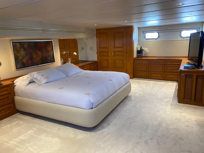 Mi Amor Yacht Photos Pics Luxurious bedroom on 1984 DeFever 120 yacht with elegant wood furnishings and large bed.