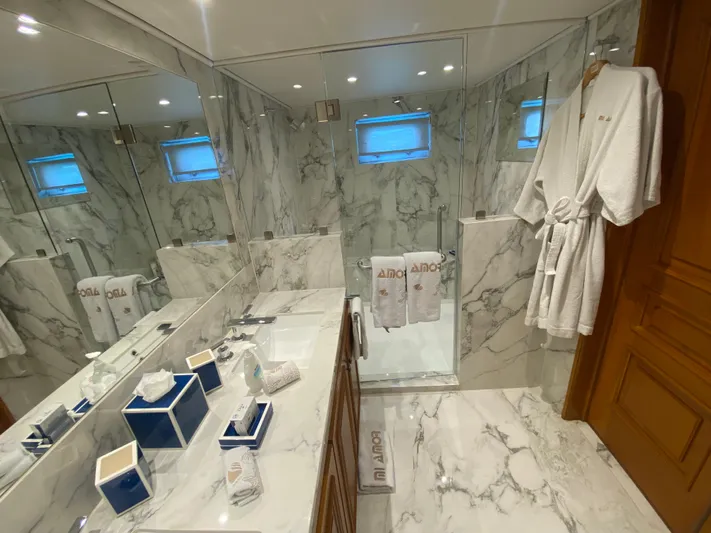 Mi Amor Yacht Photos Pics Luxurious marble bathroom on 1984 DeFever 120 yacht, featuring elegant amenities and plush robes.