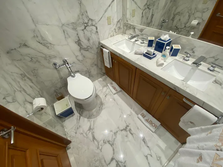 Mi Amor Yacht Photos Pics Luxurious marble bathroom in a 1984 DeFever 120 yacht, featuring dual sinks and elegant fixtures.