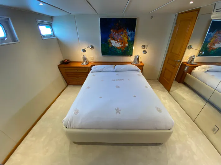 Mi Amor Yacht Photos Pics Luxurious bedroom on 1984 DeFever 120 yacht with modern decor and artwork.