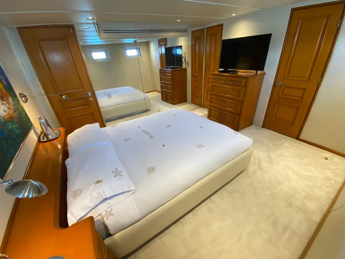Mi Amor Yacht Photos Pics Luxurious bedroom interior of 1984 DeFever 120 yacht with elegant wood furnishings.