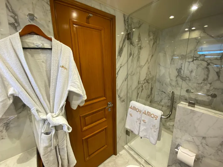 Mi Amor Yacht Photos Pics Luxurious marble bathroom on 1984 DeFever 120 yacht with robe and towel.