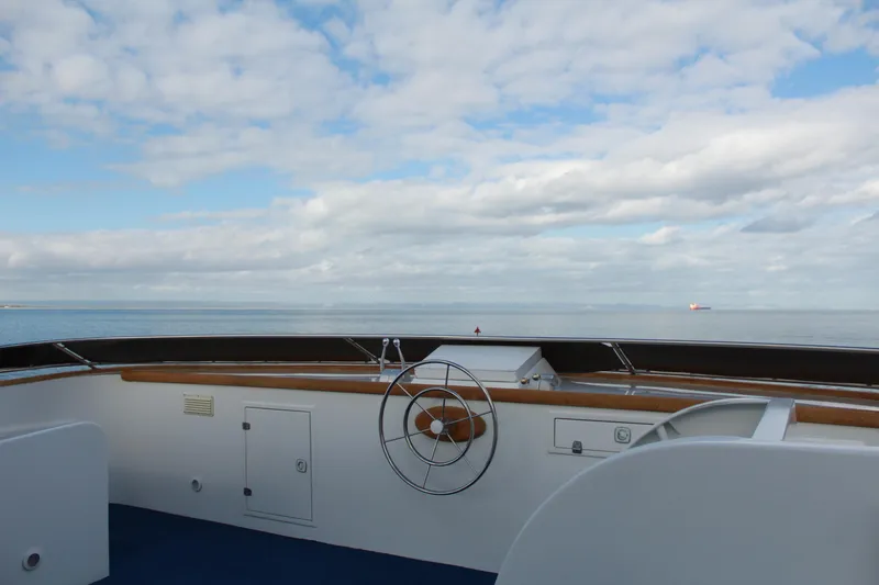 Mi Amor Yacht Photos Pics 1984 DeFever 120 yacht helm with ocean view under cloudy sky.