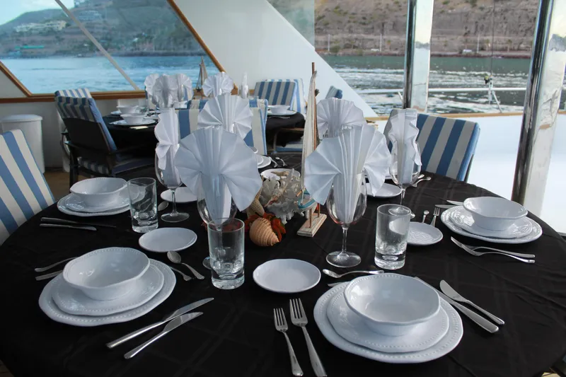 Mi Amor Yacht Photos Pics Elegant dining setup on 1984 DeFever 120 yacht with ocean view.