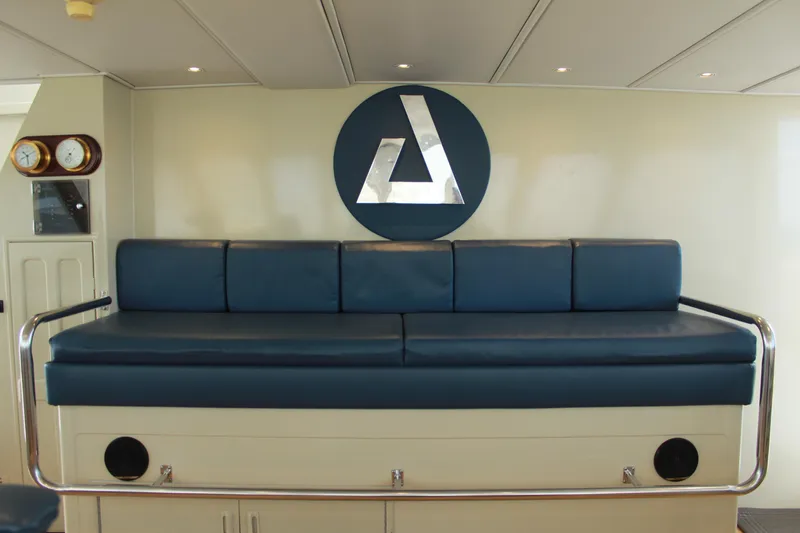 Mi Amor Yacht Photos Pics 1984 DeFever 120 yacht interior with blue cushioned seating and nautical decor.