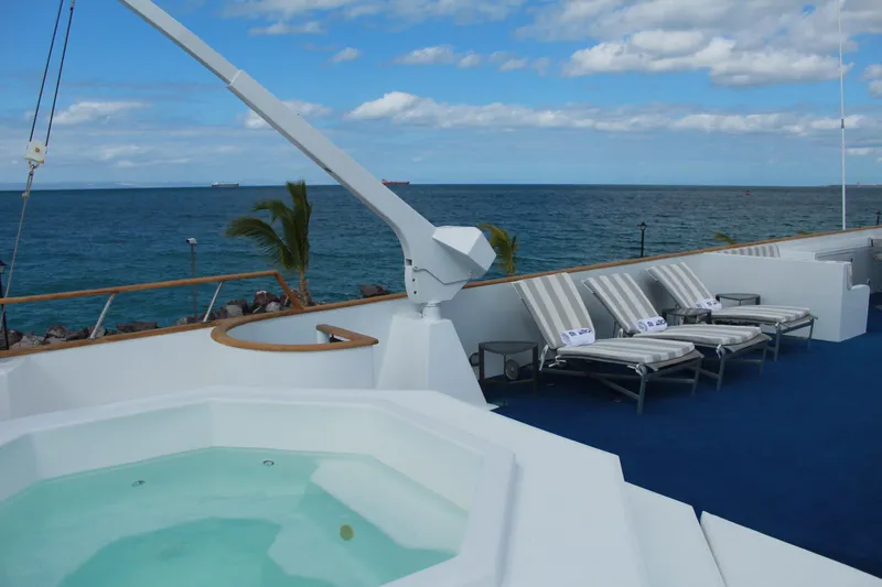 Mi Amor Yacht Photos Pics Luxurious deck of 1984 DeFever 120 yacht with jacuzzi and sun loungers, ocean view.