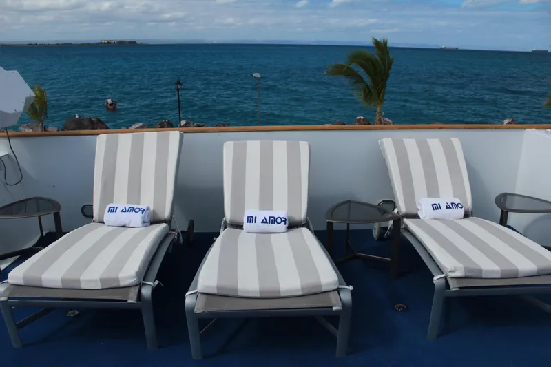 Mi Amor Yacht Photos Pics Three striped lounge chairs on a DeFever 120 yacht deck overlooking the ocean, 1984 model.