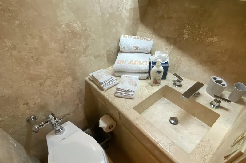 Mi Amor Yacht Photos Pics Luxurious bathroom in 1984 DeFever 120 yacht with elegant stone sink and plush towels.