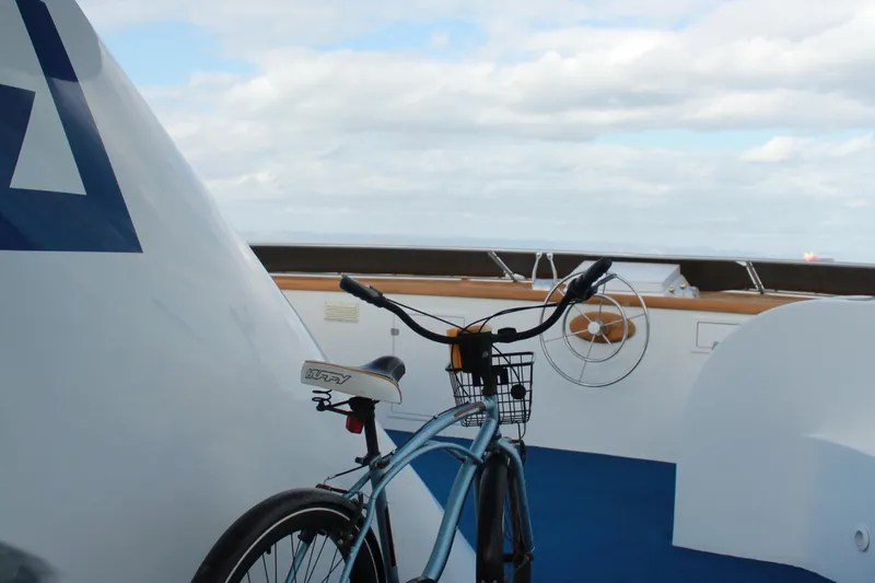 Mi Amor Yacht Photos Pics Bicycle on deck of 1984 DeFever 120 yacht, under cloudy sky.