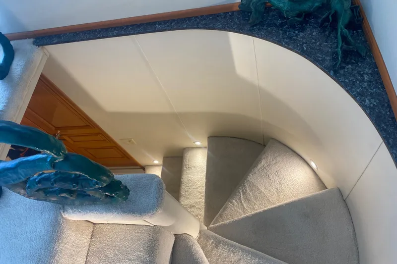 Mi Amor Yacht Photos Pics Spiral staircase inside 1984 DeFever 120 yacht with carpeted steps and elegant design.