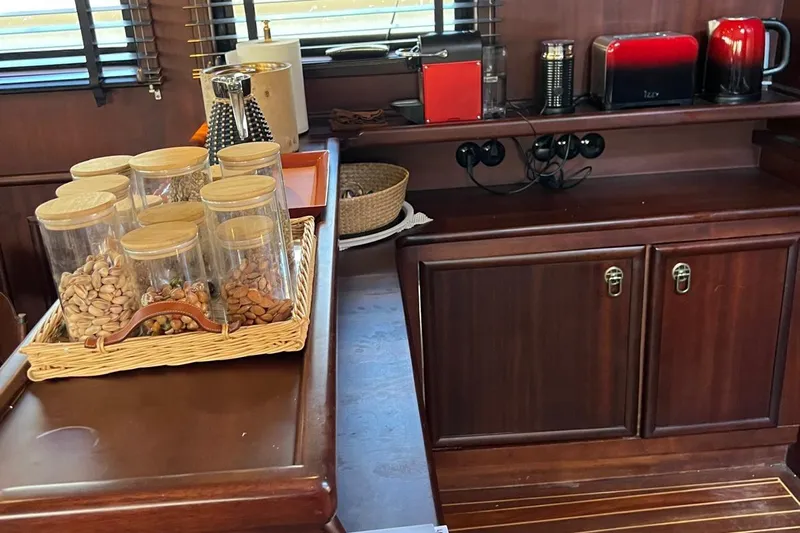  Yacht Photos Pics Luxurious yacht kitchen with wooden cabinets, snack jars, and modern appliances on Sailing Yacht Ocean Pure.