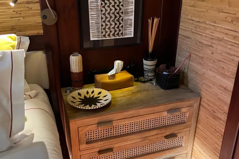  Yacht Photos Pics Cozy yacht cabin with wooden dresser, decorative items, and modern art.