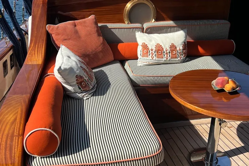  Yacht Photos Pics Luxurious seating area on 1993 Custom Sailing Yacht Ocean Pure with striped cushions and wooden table.
