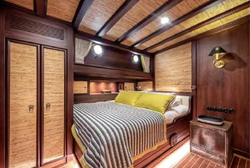  Yacht Photos Pics Luxurious cabin interior of 1993 Custom Sailing Yacht Ocean Pure with wood paneling and cozy bedding.