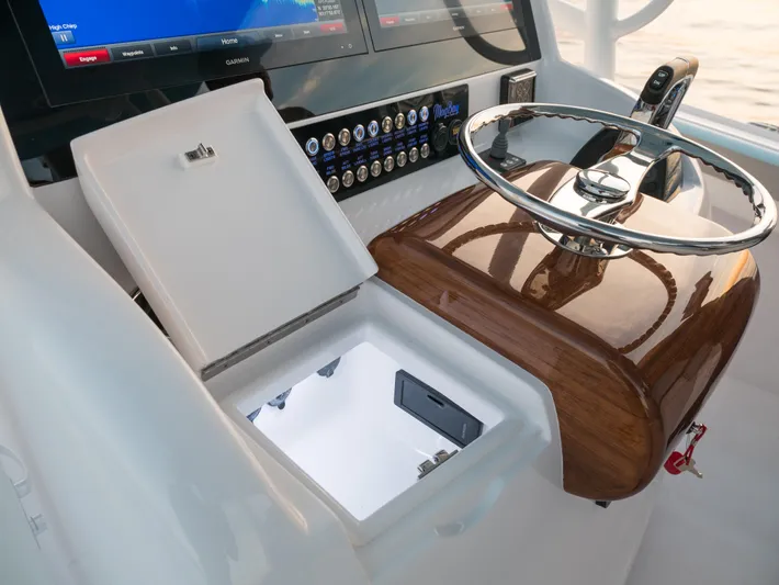  Yacht Photos Pics Mag Bay 33 2025 boat helm with open storage compartment and modern controls.