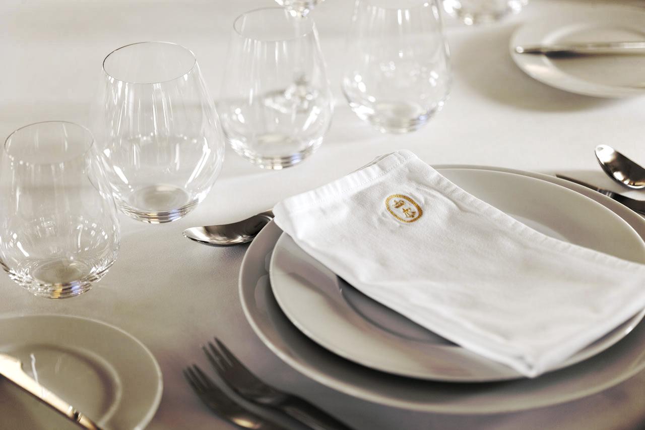 Elegant table setting with white napkin, glassware, and cutlery on Explorer 35m trawler, 2012.