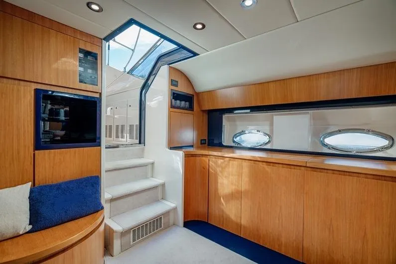  Yacht Photos Pics Luxurious interior of 1996 Riva BAHAMAS 60 SPECIAL yacht with wooden cabinetry and porthole windows.