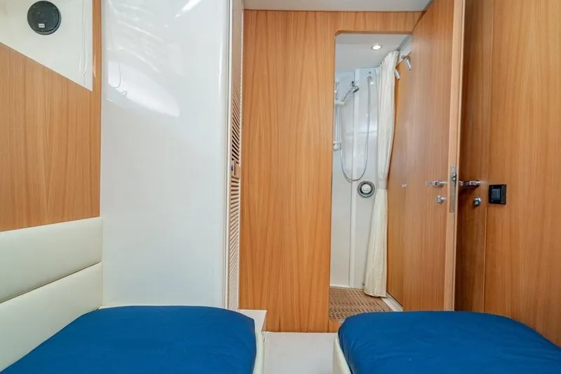  Yacht Photos Pics Interior of 1996 Riva BAHAMAS 60 SPECIAL yacht with wooden paneling and blue bedding.