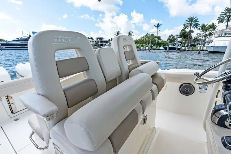  Yacht Photos Pics 2018 Boston Whaler 330 Outrage boat interior with luxurious seating and waterfront view.