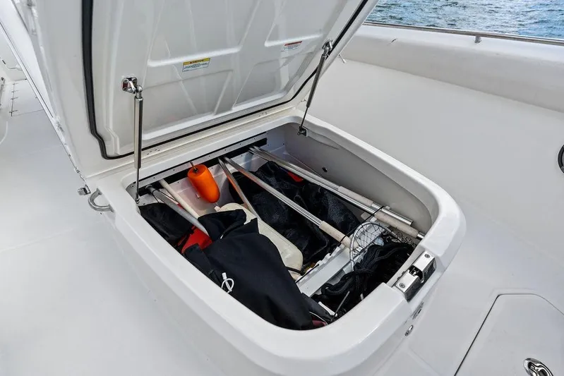  Yacht Photos Pics Open storage compartment on 2018 Boston Whaler 330 Outrage boat, containing fishing gear and equipment.