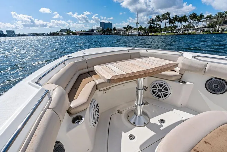  Yacht Photos Pics 2018 Boston Whaler 330 Outrage boat interior with seating and table on sunny day.