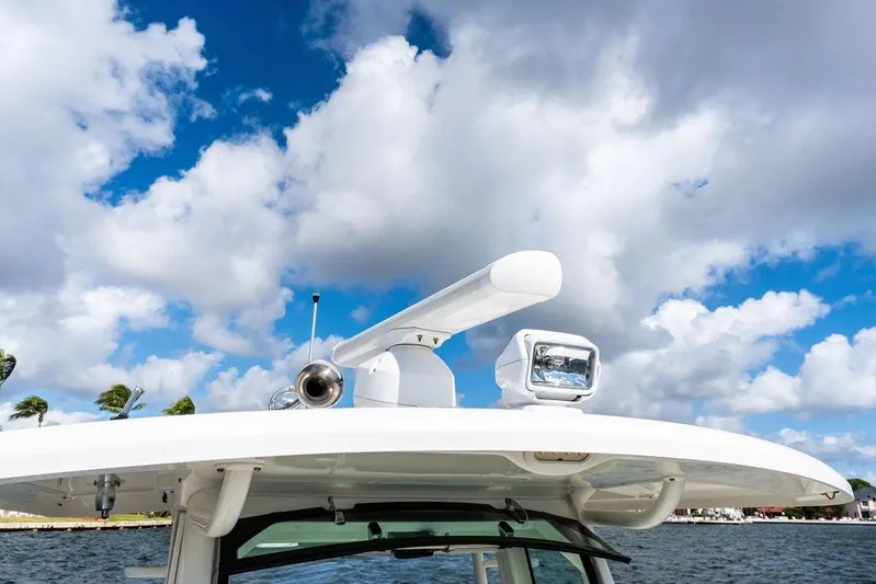  Yacht Photos Pics 2018 Boston Whaler 330 Outrage boat radar and light against cloudy sky.