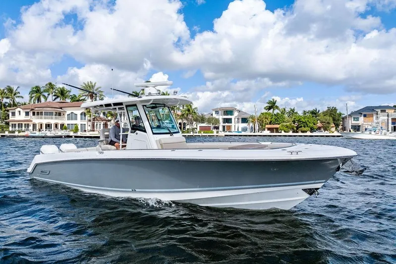  Yacht Photos Pics 2018 Boston Whaler 330 Outrage cruising on a sunny day near waterfront homes.