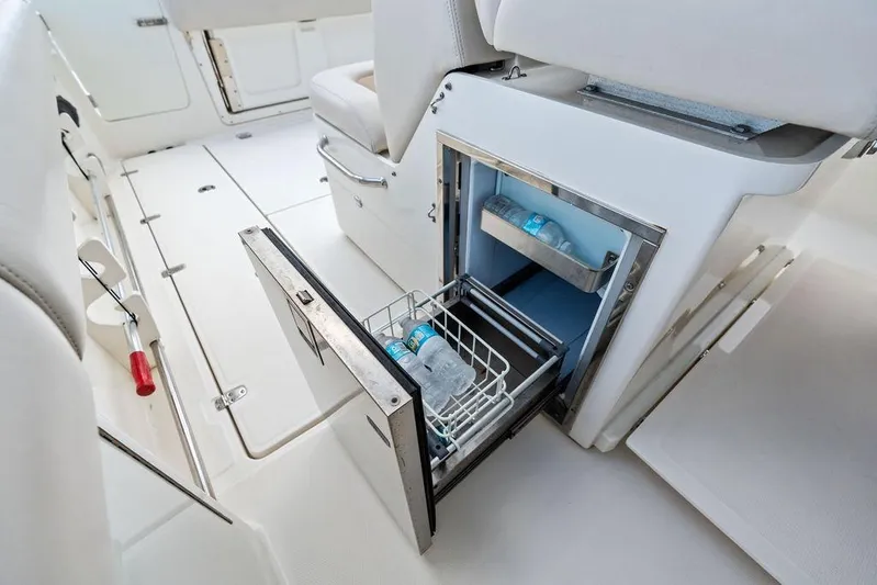  Yacht Photos Pics 2018 Boston Whaler 330 Outrage interior with open storage compartment and water bottles.