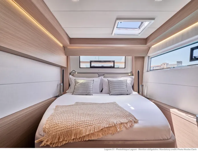  Yacht Photos Pics Luxurious cabin interior of 2024 Lagoon 51 yacht with cozy bedding and modern design.