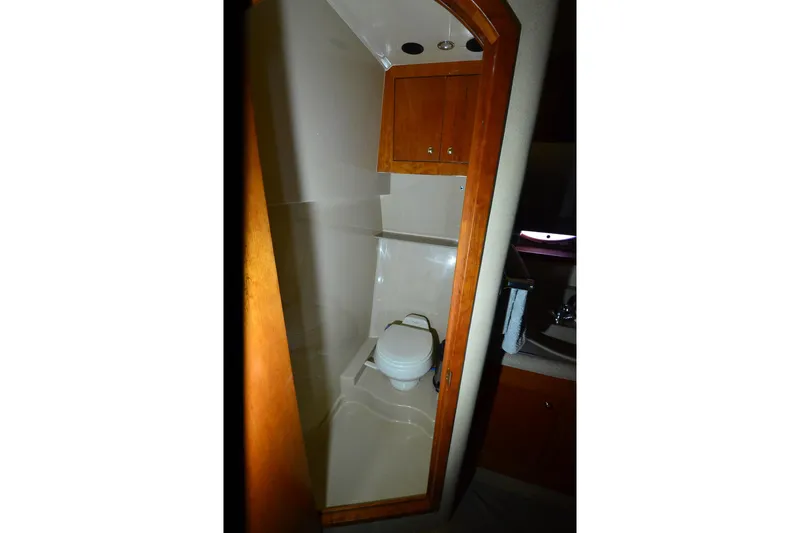 Seeking Sara Yacht Photos Pics Bathroom interior of 2003 Cruisers Yachts 4370 Express with wooden cabinetry.