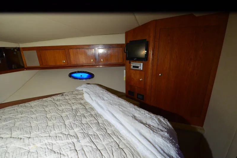 Seeking Sara Yacht Photos Pics Interior cabin of 2003 Cruisers Yachts 4370 Express with wood paneling and bedding.