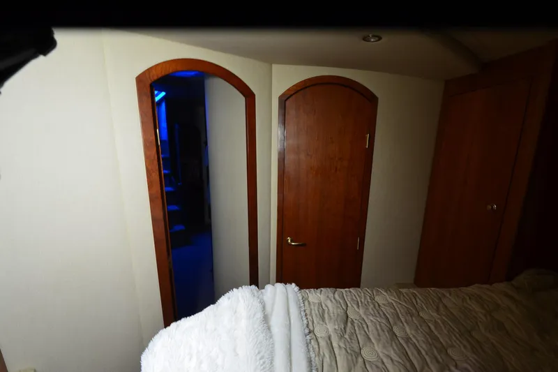 Seeking Sara Yacht Photos Pics Interior of 2003 Cruisers Yachts 4370 Express with wooden doors and cozy bedding.